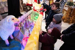 tre bambini guardare nel Natale Natività culla scena nel Chiesa. foto