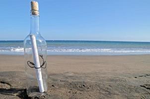 Messaggio nel un' bottiglia su un' solitario spiaggia foto