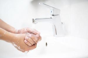 pulizia mani. lavaggio mani con sapone sotto il rubinetto con acqua pagare sporco foto