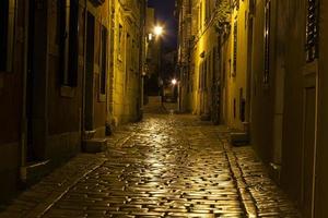 scena di un' acciottolato strada nel il storico centro di rovigno nel Croazia durante notte foto