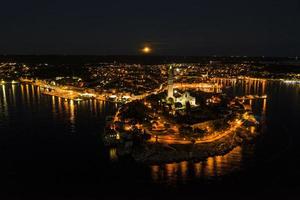 panoramico aereo fuco immagine di il storico città rovigno e porto con pieno Luna nel Croazia durante tramonto foto