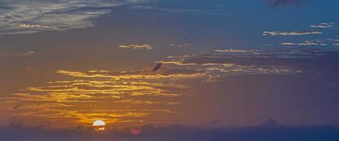 immagine di drammatico e colorato cielo con sole durante tramonto foto