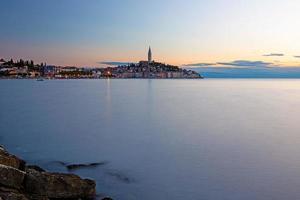 Visualizza per il storico centro di rovigno durante tramonto con acqua riflessi foto