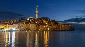 Visualizza per il storico centro di rovigno durante tramonto con acqua riflessi foto