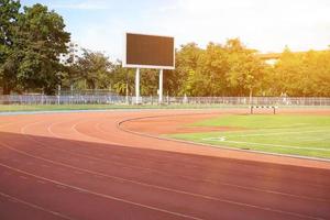 scena di calcio campo con tabellone segnapunti e raggio di sole cielo. foto