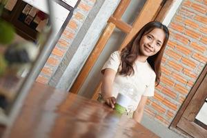 donna asiatica che sorride felicemente in un caffè foto