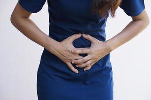 la donna soffre di mal di stomaco gastrite cronica concetto di gonfiore addominale foto