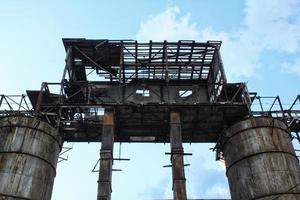 arrugginito strutture tubi di un vecchio abbandonato distrutto industriale acciaio fabbrica. il coperto di vegetazione rovine di complesso edificio la zona. il concetto di fallimento, e il chiusura di produzione e lavori foto