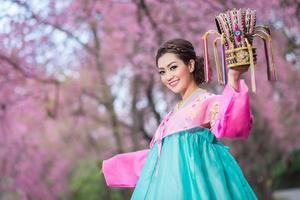 hanbok, il tradizionale coreano vestito e bellissimo asiatico ragazza con sakura foto