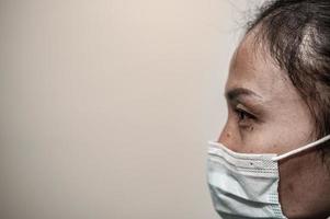 stanco depresso donna asiatica scrub infermiera indossa maschera facciale uniforme blu siede sul pavimento dell'ospedale, giovane donna medico stressato dal duro lavoro foto