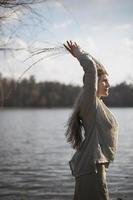 vicino su autentico donna in posa nel davanti di lago nel pagano attrezzatura ritratto immagine foto