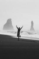 eccitato turista su vuoto nero spiaggia monocromatico panoramico fotografia foto