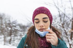 non fare toccare il tuo viso, fermare diffusione coronavirus. giovane donna toccante sua bocca con sporco mano. evitare toccante il tuo viso. donna mettendo giù viso maschera sfregamento sua labbro all'aperto. foto