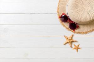 cannuccia cappello, sole bicchieri e conchiglie su un' bianca di legno sfondo. superiore Visualizza estate vacanza concetto con copia spazio foto