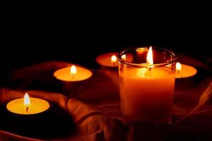 profumato candele nel il buio notte su un' rosso stoffa, cerimonia, speranza, romantico foto