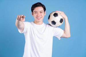 giovane asiatico uomo Tenere palla su sfondo foto
