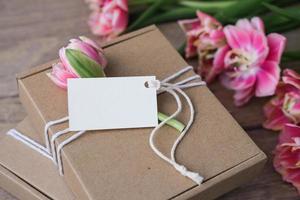 finto su etichetta e kraft regalo scatole decorato con fiori. preparazione di i regali per La madre di giorno, compleanno, Da donna vacanza. regalo involucro idea foto
