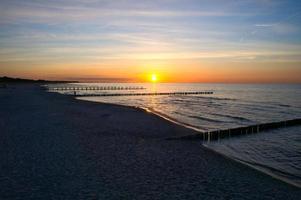 tramonto su il baltico mare. mare, frangiflutti forte colori. vacanza su il spiaggia. romantico foto
