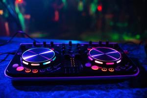 dj consolle per miscelazione musica con sfocato persone danza a un' discoteca festa foto