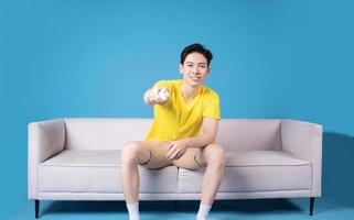 Immagine di giovane asiatico uomo seduta su divano foto