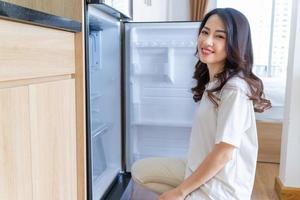 Immagine di giovane asiatico donna con frigo foto