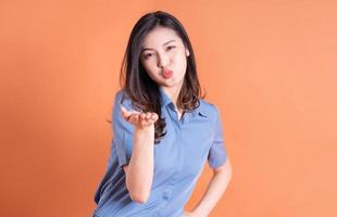 giovane donna asiatica d'affari in posa su sfondo arancione foto