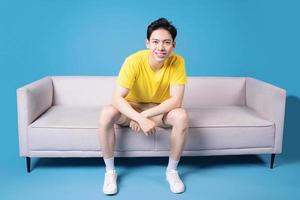 Immagine di giovane asiatico uomo seduta su divano foto