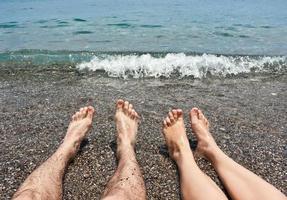 paio gambe su mare spiaggia foto