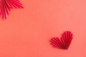 modello con origami cuore e foglia. rosso monocromatico sfondo. copia spazio foto