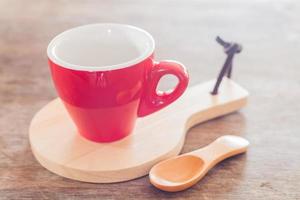 tazza rossa con un piatto di legno foto