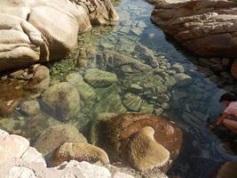 chiaro sorprendente azzurro colorato mare acqua con granito rocce foto