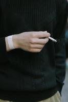 uomo che tiene una sigaretta in mano foto