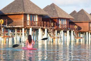 donna paddleboarding in un resort