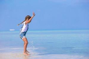 ragazza che salta in acqua in spiaggia foto