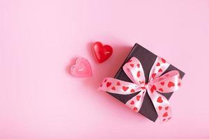 presente regalo scatola con arco su rosa sfondo. san valentino giorno regalo piatto posare foto