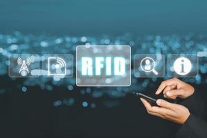 RFID, Radio frequenza identificazione concetto, persona utilizzando il computer portatile computer e mano toccante rfid icona su virtuale schermo. foto