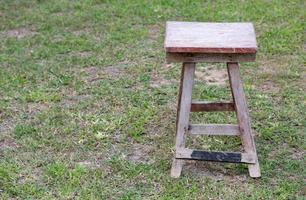 vecchio di legno sedia nel il erba campo all'aperto foto