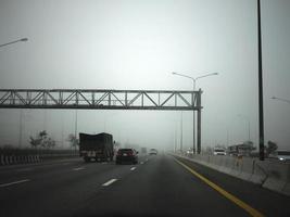 strada nel il nebbia, cartello citare mantenere distanza per autostrada-t7.svg foto