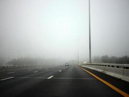 strada nel il nebbia, cartello citare mantenere distanza per autostrada-t7.svg foto