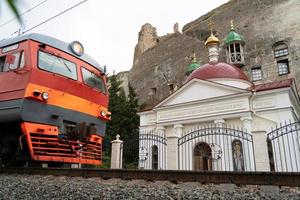 un' Chiesa nel il mezzo di un' roccioso pietra montagna vicino un' ferrovia foto