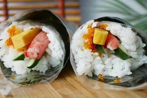 Sushi rotolo con salmone, gamberetti e riso rotolo su tavolo foto