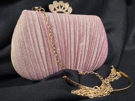 il splendente rosa Borsa sembra elegante con un' d'oro colorato catena cinghia adatto per andando per parti o inviti foto