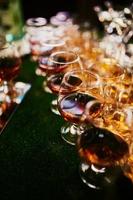 bicchieri con Cognac, whisky In piedi su il sbarra. un' lotto di bicchieri con Cognac. alcool nel il occhiali. vario alcool bevande in piedi su sbarra. bicchieri con Cognac su il bar foto