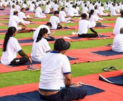 nuovo delhi, India, giugno 21 2022 - gruppo yoga esercizio sessione per persone a yamuna gli sport complesso nel delhi su internazionale yoga giorno, grande gruppo di adulti frequentando yoga classe nel cricket stadio foto