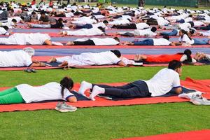 nuovo delhi, India, giugno 21 2022 - gruppo yoga esercizio sessione per persone a yamuna gli sport complesso nel delhi su internazionale yoga giorno, grande gruppo di adulti frequentando yoga classe nel cricket stadio foto