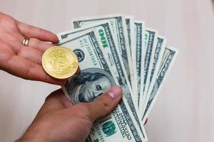 d'oro bitcoin moneta su Da donna mano su sfocato noi dollaro fatture sfondo copia spazio foto