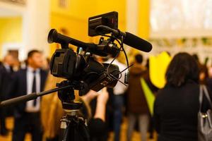 dietro a il scena concetto. cineoperatore Lavorando su professionale telecamera assunzione film intervistatore colloquio celebrità persone fabbricazione notizia all'aperto. foto