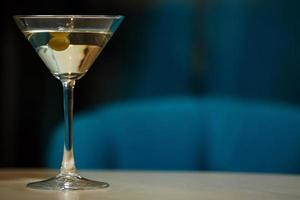 bicchiere con martini, focus su un olive foto