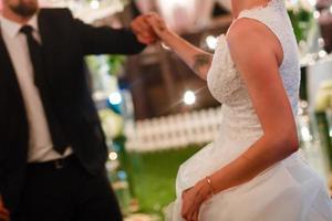 sposo detiene sposa S mano danza con sua nel il mezzo di un' ristorante foto