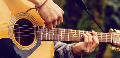 giovane musicista giocando chitarra vicino su foto